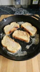 Brioche French Toast cooking with first side turning golden