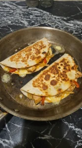 Chicken Quesadillas browning with melted cheese and crisp tortillas.