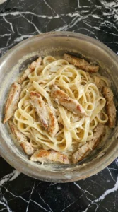 Chicken and fettuccine coated in creamy alfredo sauce.