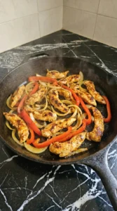 Cooked chicken with onion and red bell pepper for Chicken Quesadillas.