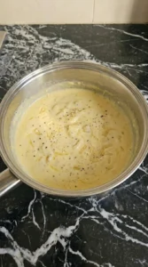 Parmesan melting into garlic cream sauce for Creamy Garlic Parmesan Pasta.