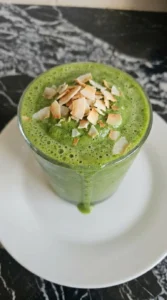 Detox Green Smoothie poured into glasses with toasted coconut flakes