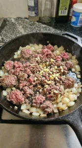 Ground beef browning with onion and garlic for Easy Ground Beef Tacos.