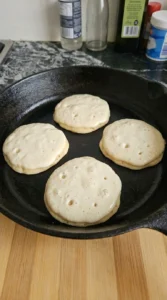 Pancakes cooking on the first side with bubbles and set edges