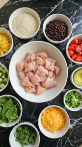 Raw diced chicken and measured toppings prepared for a chicken bowl