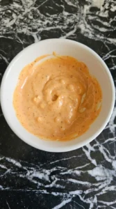 Thick high protein sauce mixed in a small white bowl