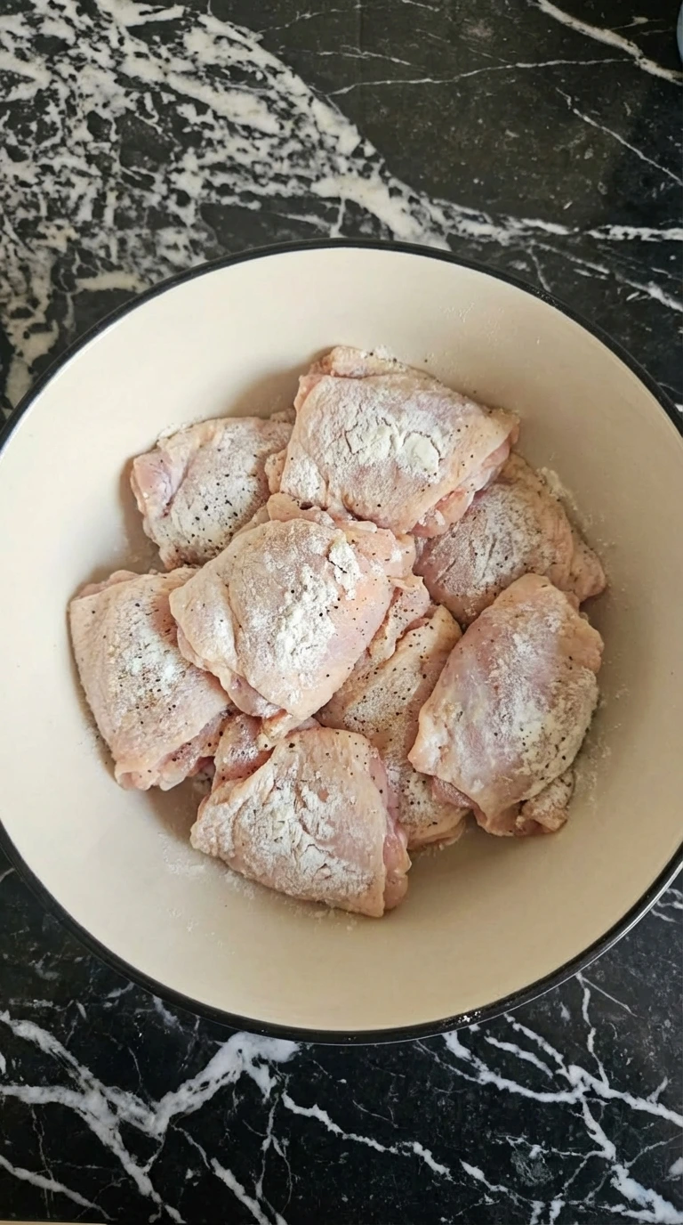 Chicken thighs coated with cornstarch and seasoning for Honey Garlic Chicken.