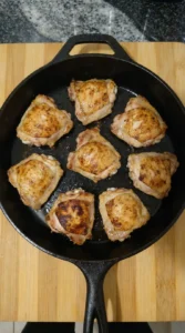 Chicken thighs browning in the skillet for Honey Garlic Chicken.