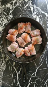 chicken with garlic and lemon slices scattered in skillet