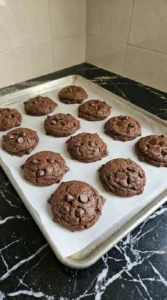 Baked chocolate cookies with crackled tops on a tray.