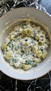 Spinach and artichokes folded into creamy dip mixture.
