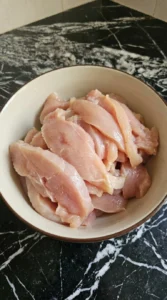 thin sliced raw chicken in bowl