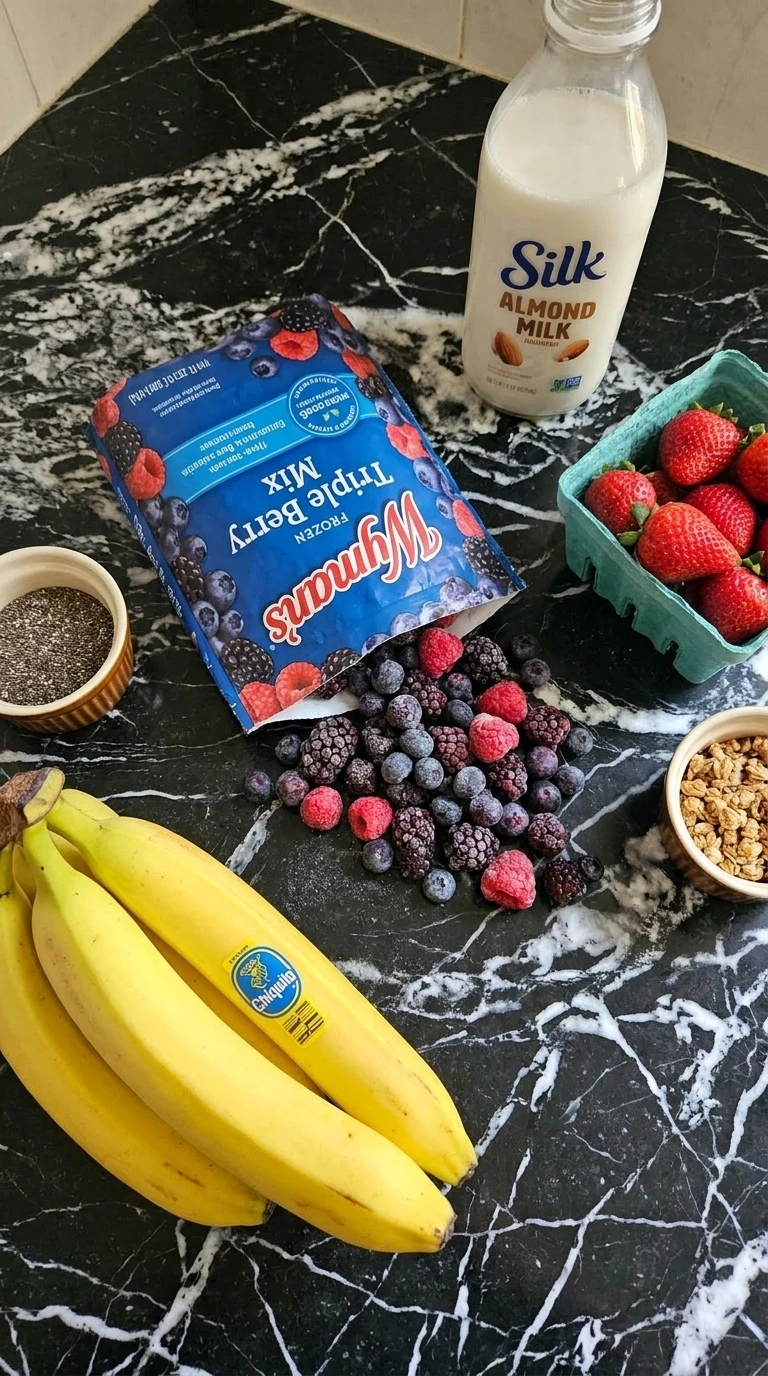 Ingredients for berry smoothie bowl including frozen berries and almond milk