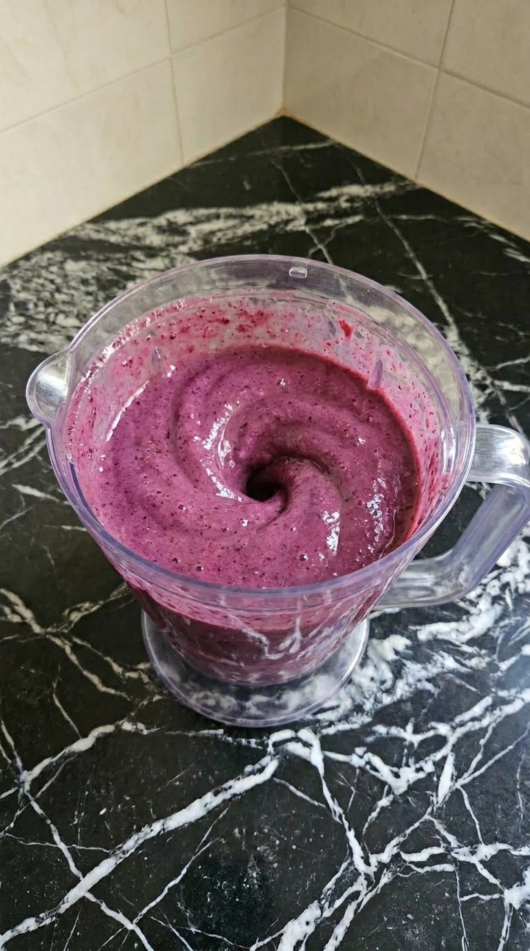Thick purple smoothie mixture inside a blender