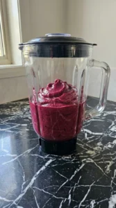 Thick purple smoothie base inside a blender jar