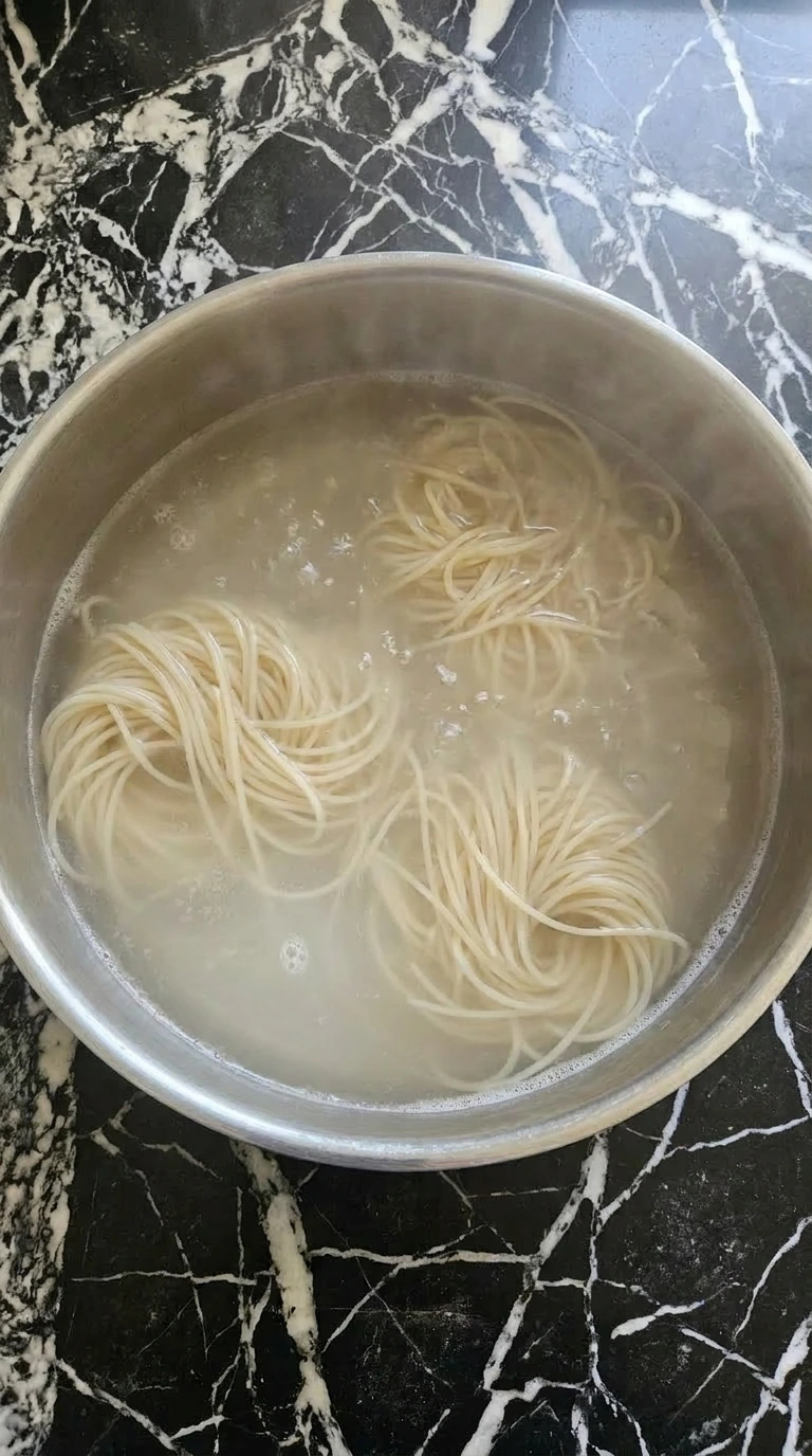 Spaghetti noodles boiling in a large pot of water on the stove