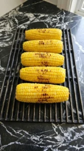 Corn cobs with char marks on a hot grill