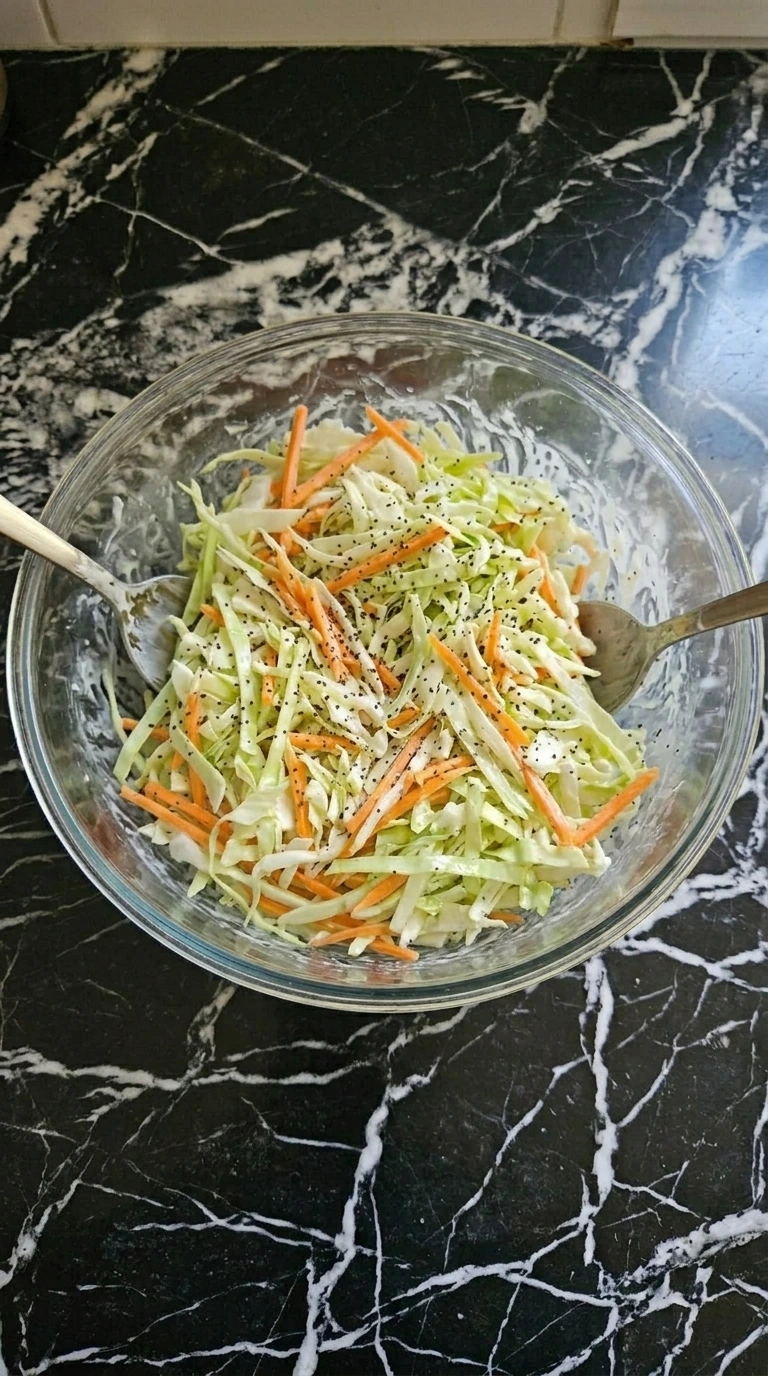Tossing shredded cabbage and carrots with creamy dressing.