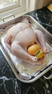 Stuffed raw turkey in a roasting pan before cooking