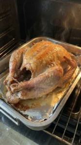 Golden brown turkey roasting inside an oven