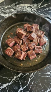 Searing beef cubes in a cast iron skillet