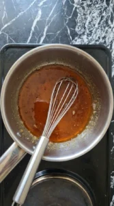 A bubbling honey and brown sugar glaze simmering in a saucepan.
