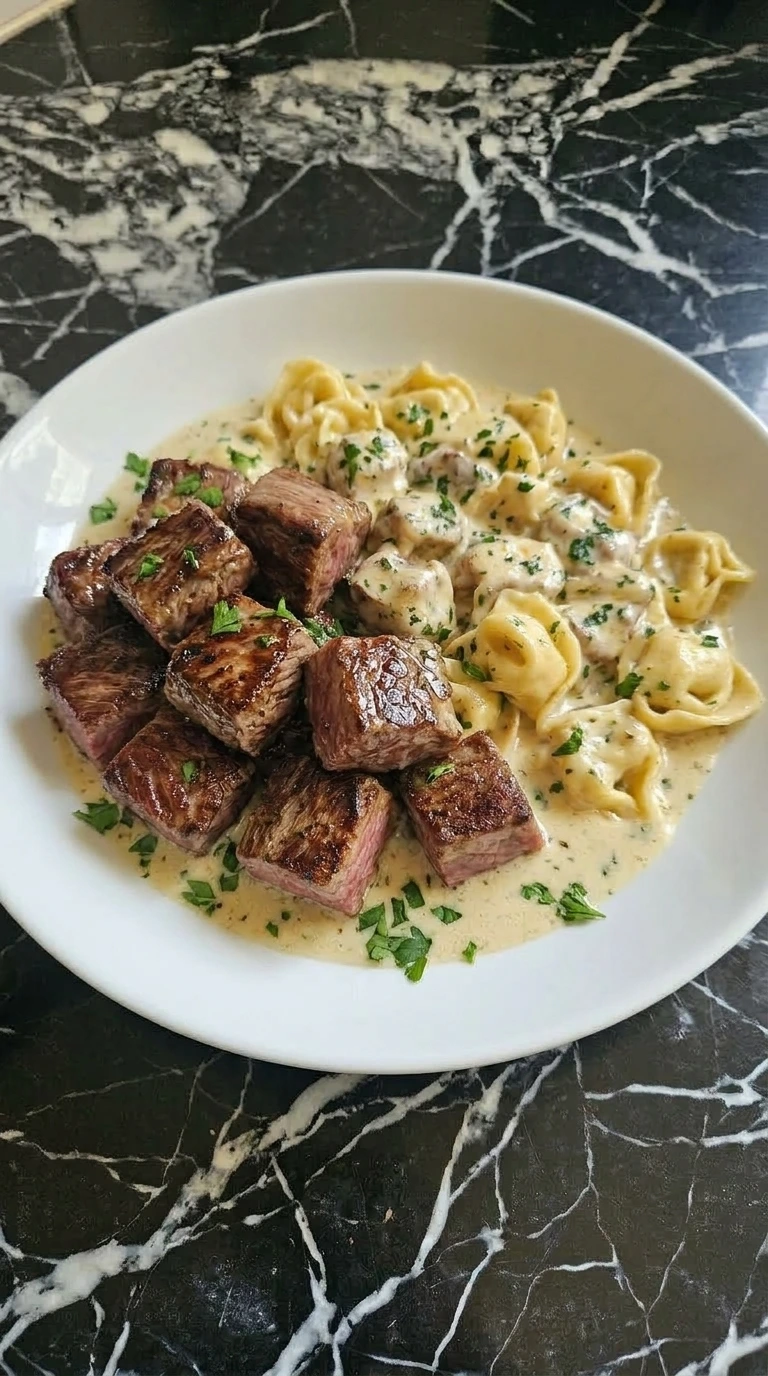 Steak with Garlic Butter and tortellini on a white plate