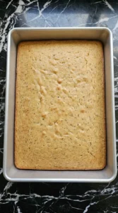 Golden Banana Cake baked in a 9×13-inch pan with a level set center.