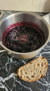 Blackberry jam simmered until glossy with some berries left whole