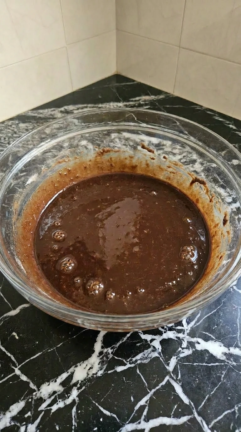 Glossy liquid chocolate cake batter after adding hot coffee