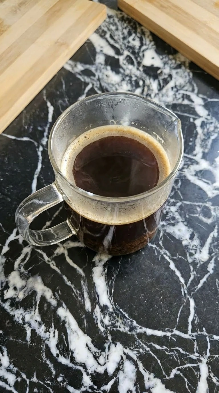 Freshly brewed concentrated dark coffee in a clear glass jug