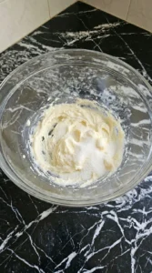Creamed butter and white sugar mixture in a glass bowl