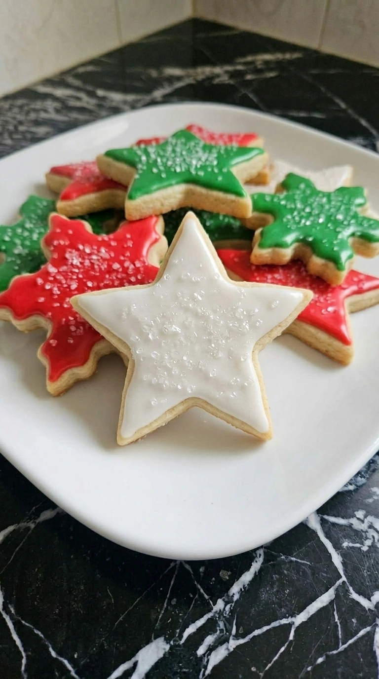 A close-up of a decorated star sugar cookie with icing and sprinkles