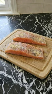 Raw salmon fillets topped with garlic powder salt and pepper rub