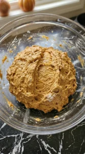 Shaggy orange pumpkin sourdough dough mixed in a glass bowl. Recipe focus: Fall Sourdough Bread Recipes.
