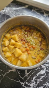 Melting sharp cheddar into Bacon Cheeseburger Potato Soup Instant Pot Recipe until the broth turns silky