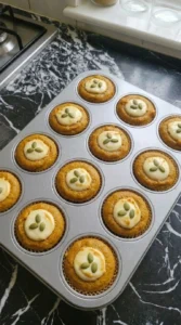 Baked Pumpkin Cream Cheese Muffins with domed tops and set centers in a muffin tin.