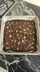 Baked sweet potato brownies with a crackled cocoa top and melted chocolate chips.