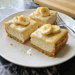 Plate of homemade Banana Cheesecake Bars garnished with banana slice Recipe focus: accents.
