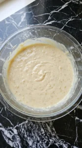Mixing batter for Banana Cheesecake Bars with hand mixer Recipe focus: accents.