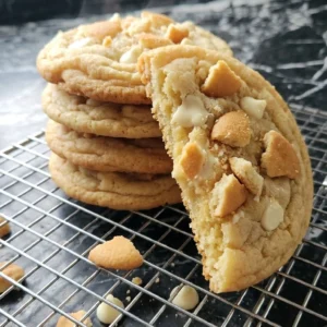 Banana Pudding Cookies topped with crushed vanilla wafers on a cooling rack