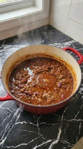 Thickened Boilermaker Tailgate Chili: The Hearty One-Pot Game Day Recipe simmering in Dutch oven Recipe focus: Boilermaker Tailgate Chili Recipe.