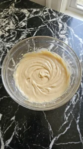 Creamed butter and sugars for Cranberry White Chocolate Cookies in a clear glass bowl