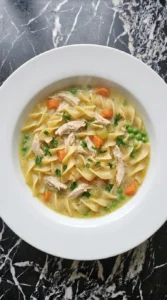 Finished bowl of Cream of Chicken Soup Recipes Crockpot Families Can Make on Busy Nights with chicken, noodles, peas and parsley.