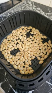 Crispy Air Fryer Pumpkin Seeds (Ready in 15 Minutes) turning light gold in the air fryer