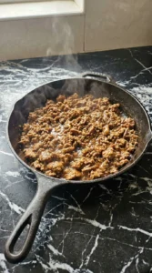 Browning ground beef for CrockPot Beefy Potato Taco Casserole in a skillet