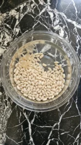 Ham and Bean Soup Recipes Crockpot: Slow Cooker Comfort Dinner step 1 showing plump soaked Great Northern beans in clear water.
