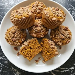 Low Carb Pumpkin Muffins Recipe with golden pecan streusel and one muffin broken open Recipe focus: keto muffins easy.