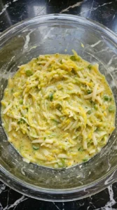 Thick patty pan squash pancake batter with cheddar and scallions