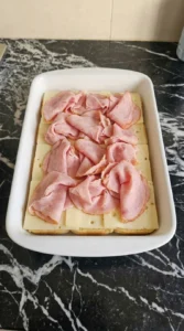 Layering ham and cheese for Sassy Tailgate Sandwiches: Hot Ham and Cheese Sliders for Game Day Recipe focus: How To Make Tailgate Sandwiches.